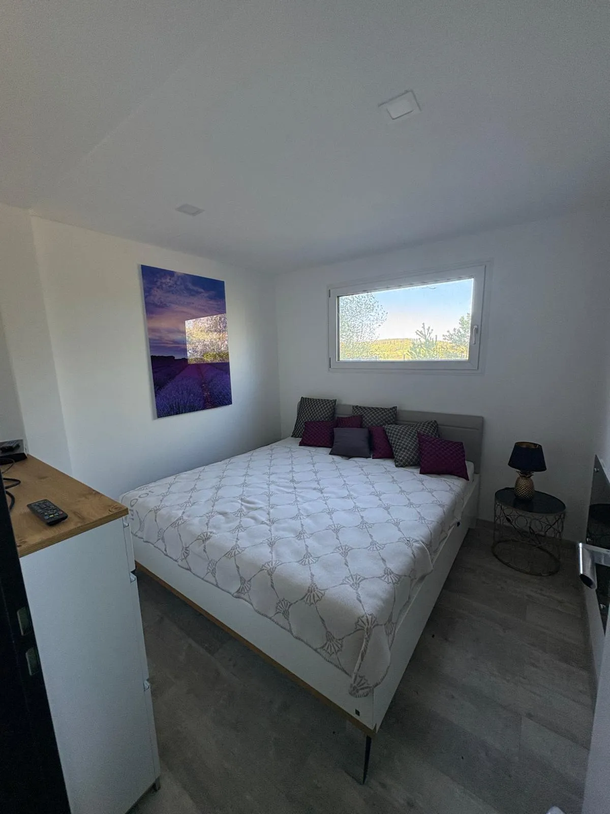 Helles Schlafzimmer mit Panoramafenster und Holzakzenten